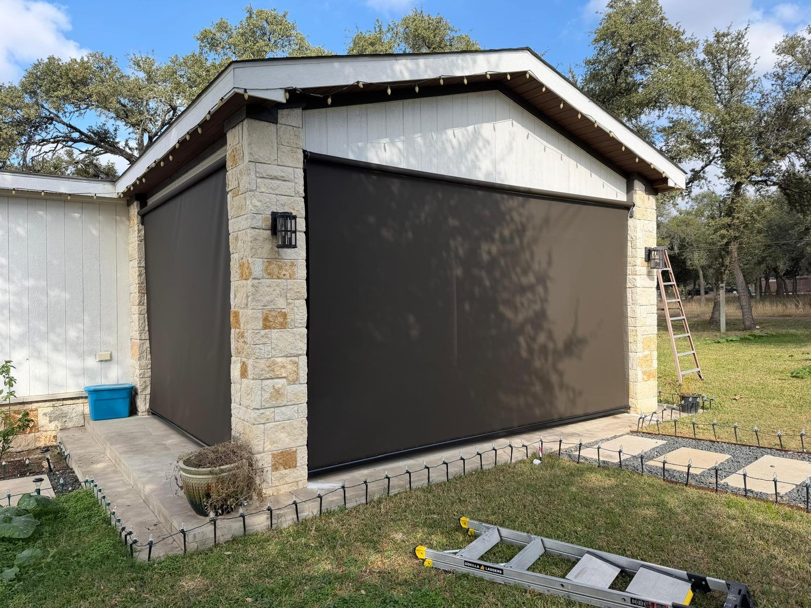 Gray solar screen on a stone-facade home