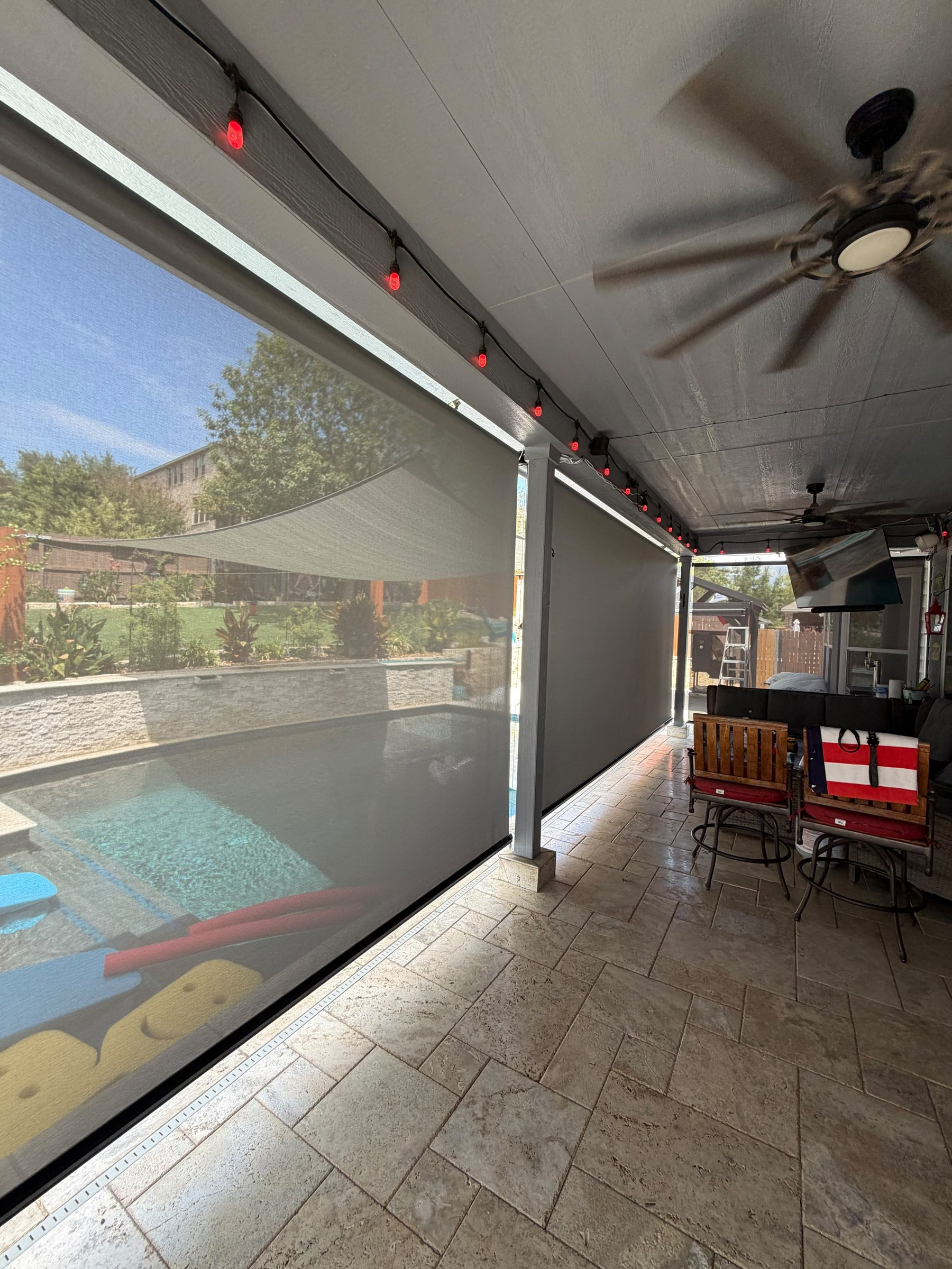 Light gray solar screen on a covered terrace with furniture