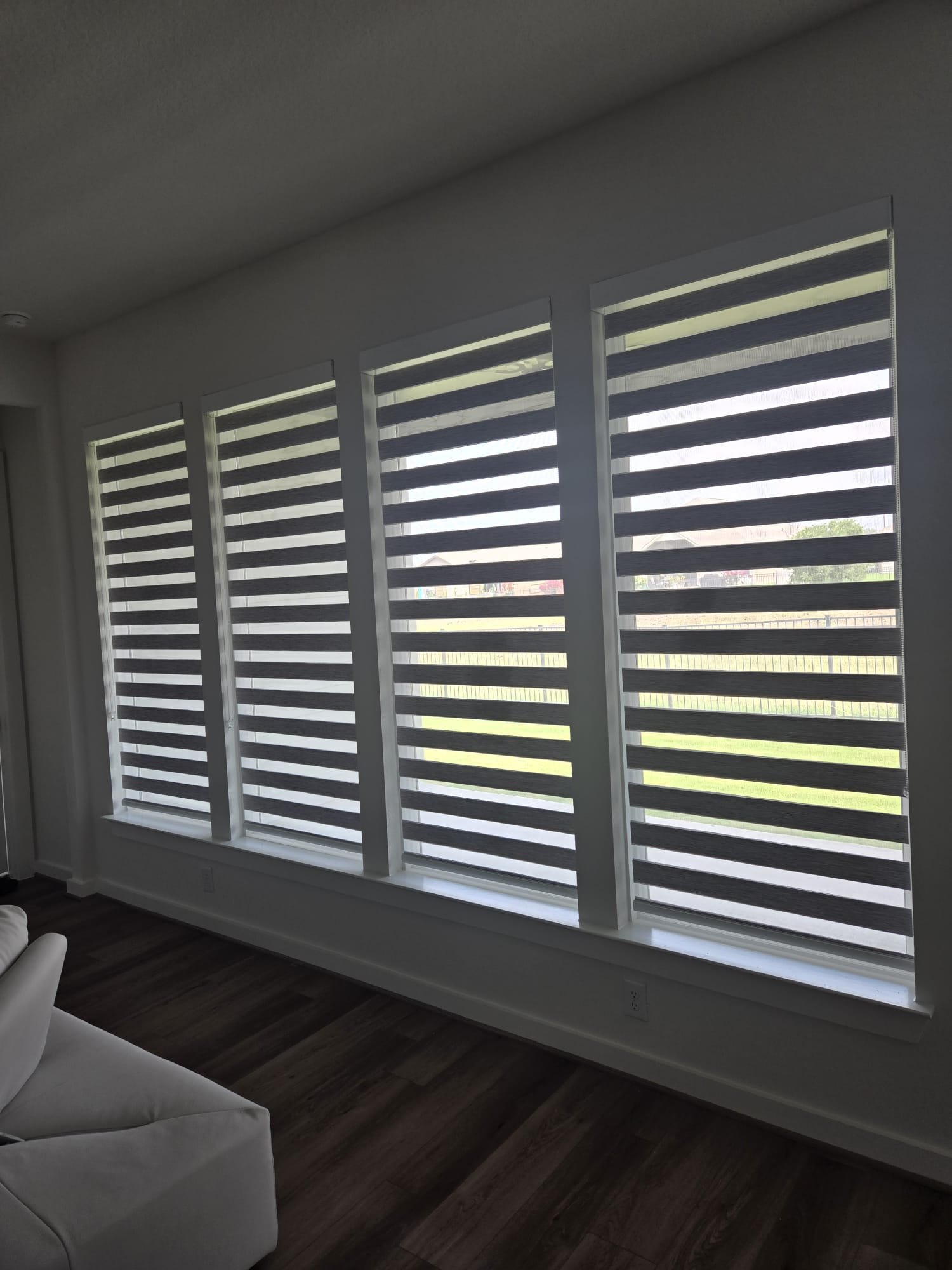 White zebra shade in a living room with a sectional sofa